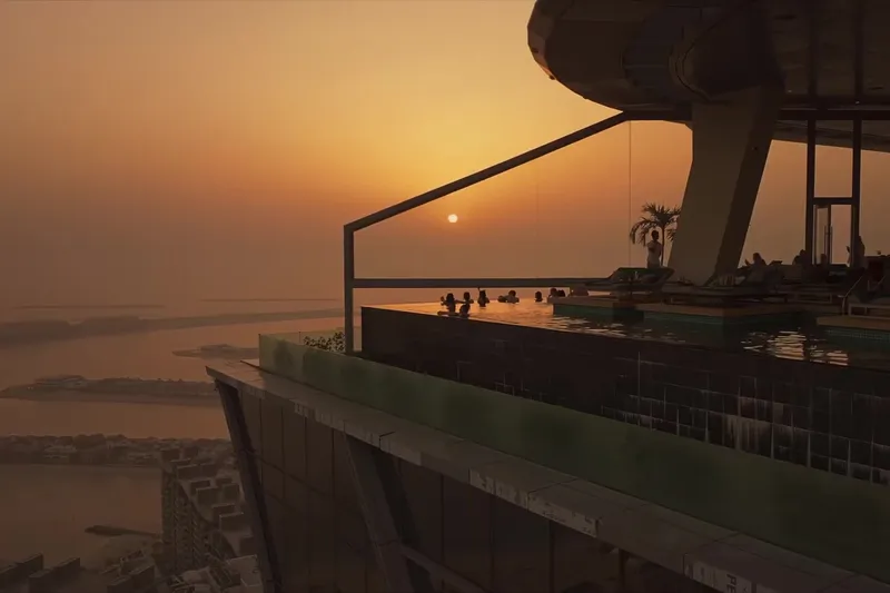 Аэроснимок башни Aura Skypool и окружающего городского пейзажа Дубая на фоне береговой линии.