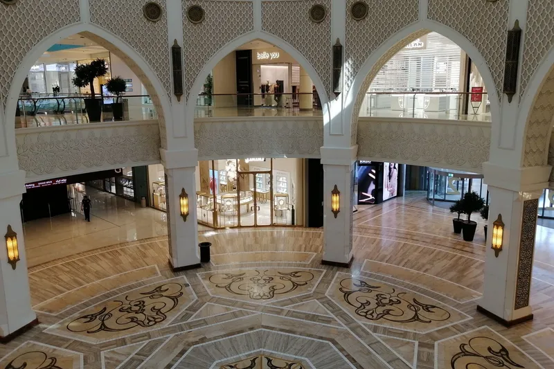 Многоуровневый атриум с магазинами и декоративными арками в Dubai Mall