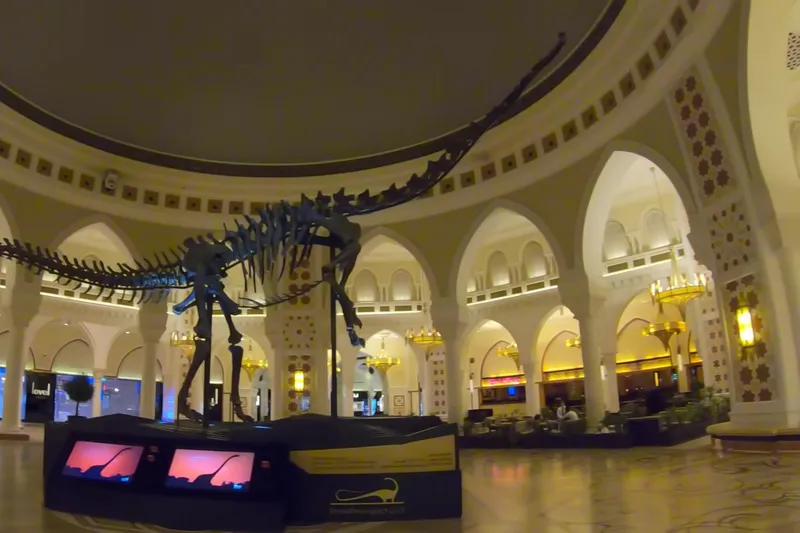 Интерьер Dubai Mall с экспозицией скелета динозавра и магазинами