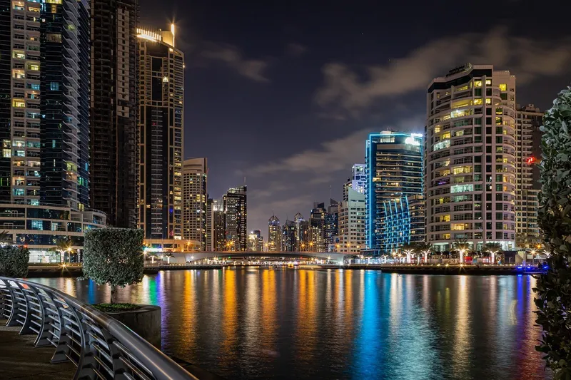 Широкая пешеходная набережная Dubai Marina вдоль канала в окружении жилых небоскребов