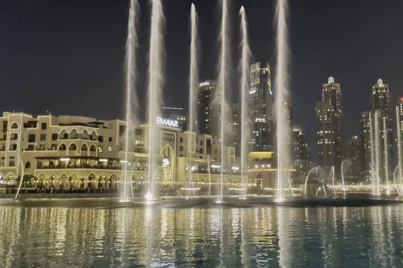 Вечернее шоу фонтанов у Dubai Mall на фоне небоскрёбов Дубая