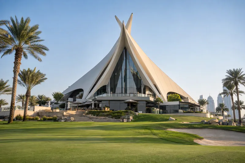 Белоснежные шатровые павильоны клабхауса Emirates Golf Club в окружении ухоженного газона и пальм.