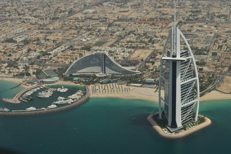 Панорамный вид Дубая с высоты: отель Burj Al Arab, пляж и яхтенная марина