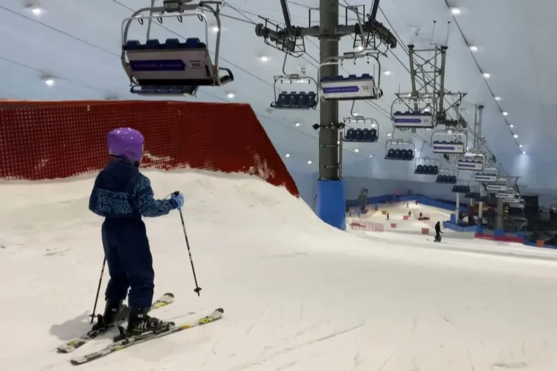 Горнолыжный склон Ski Dubai с кресельным подъёмником и лыжником на снегу