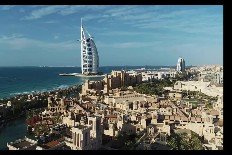 Вид с воздуха на традиционную архитектуру курорта Madinat Jumeirah и отель Burj Al Arab на фоне вод Персидского залива.