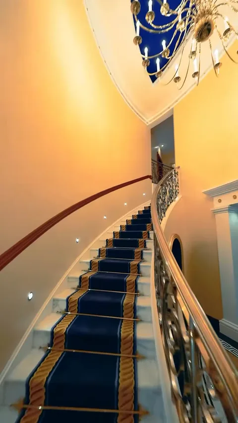 Винтовая лестница Королевского люкса Burj Al Arab с синей дорожкой и позолоченными перилами