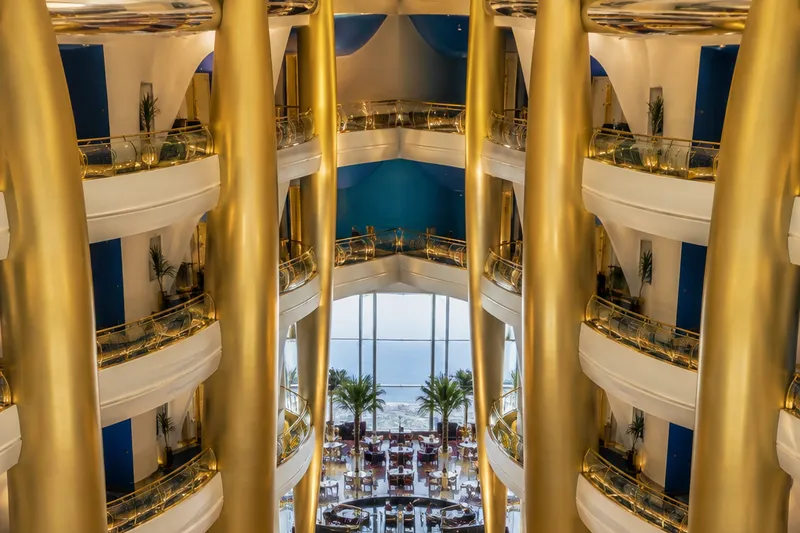 Роскошный золотой атриум отеля Burj Al Arab с фонтаном и многоуровневыми галереями