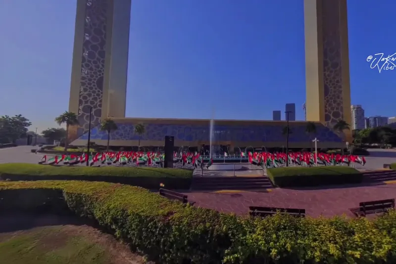Основание архитектурного сооружения Dubai Frame в парке Zabeel, украшенное множеством флагов ОАЭ.