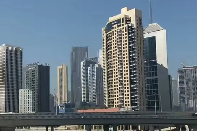 Вид на высотные здания Дубая и эстакаду скоростной магистрали Al Khail Road на фоне ясного неба.
