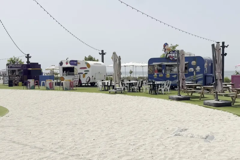 Кафе и фудтраки на песчаной территории пляжа Kite Beach в Дубае