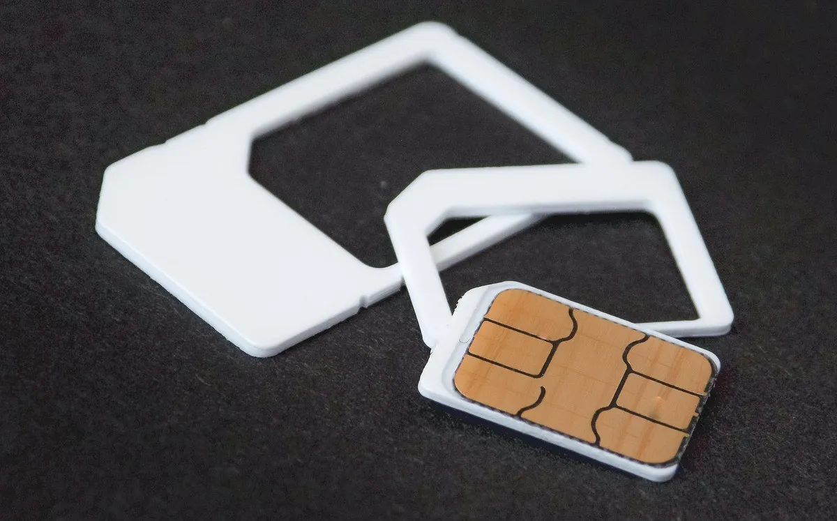 SIM-карта и держатель на тёмной поверхности