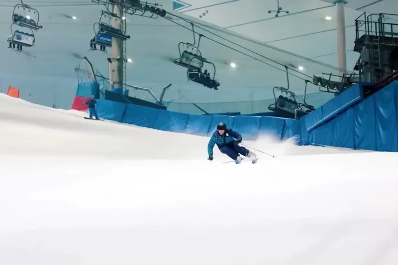 Лыжник спускается по крытому склону Ski Dubai