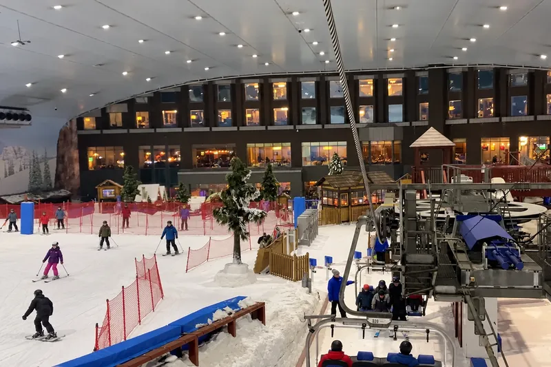 Горнолыжный склон Ski Dubai под куполом: кресельный подъёмник, снег и лыжники