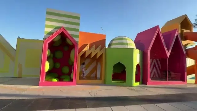 Детская игровая площадка с разноцветными конструкциями в форме домиков, расположенная на территории набережной Dubai Creek Harbour.