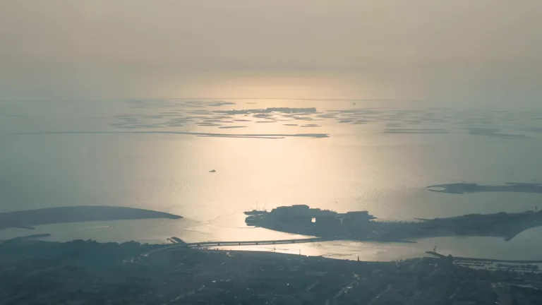 Искусственный архипелаг The World у побережья Дубая, снятый с воздуха в лучах заходящего солнца.