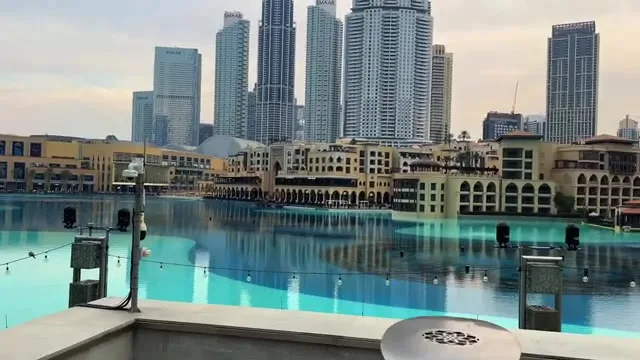 Архитектурный ансамбль рынка Сук Аль-Бахар и соседних отелей, отражающийся в спокойной глади искусственного озера.