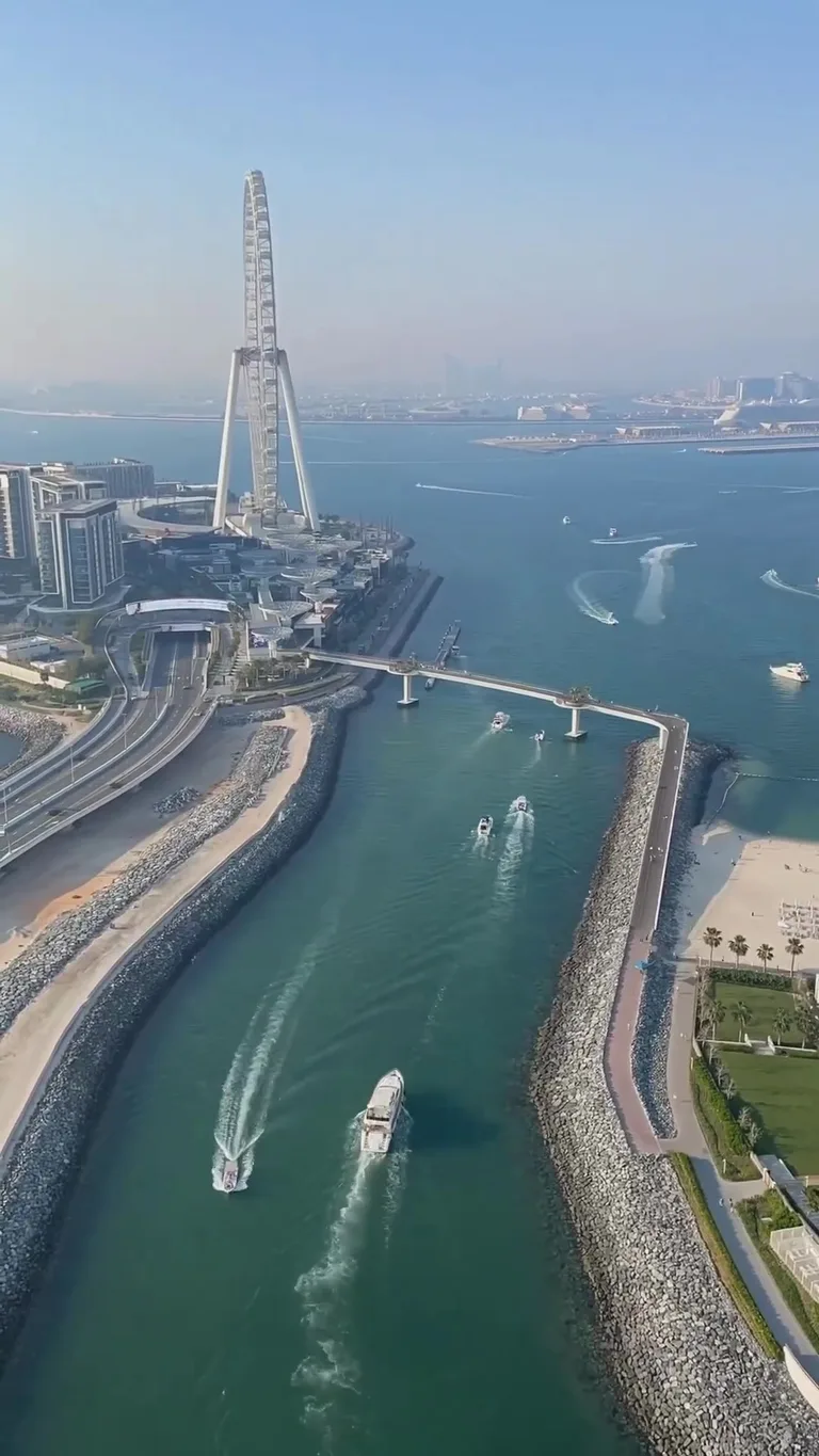 Аэросъемка извилистой реки, протекающей между изумрудными холмами под мягким светом пасмурного неба.