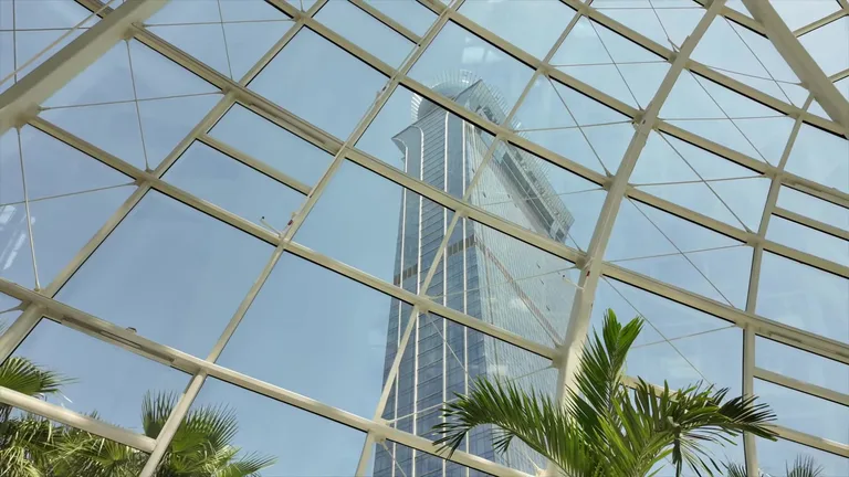 Вид снизу вверх на современный небоскреб Palm Tower сквозь стеклянный купол здания.