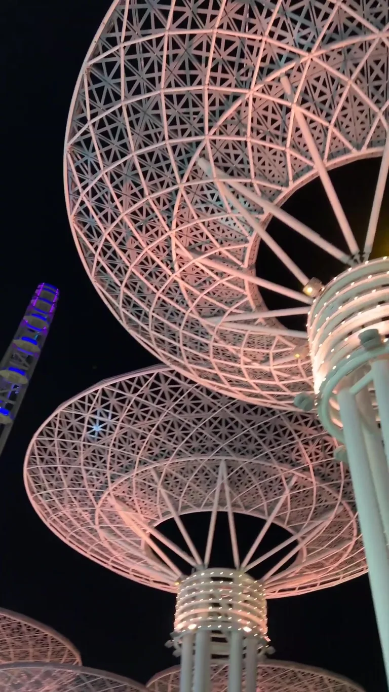 Природная скальная арка в прозрачной бирюзовой воде у подножия высоких береговых утесов с песчаным пляжем.