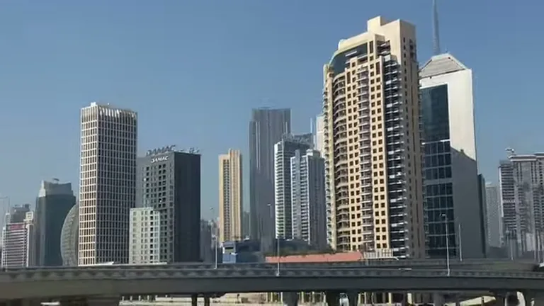 Вид на высотные здания Дубая и эстакаду скоростной магистрали Al Khail Road на фоне ясного неба.