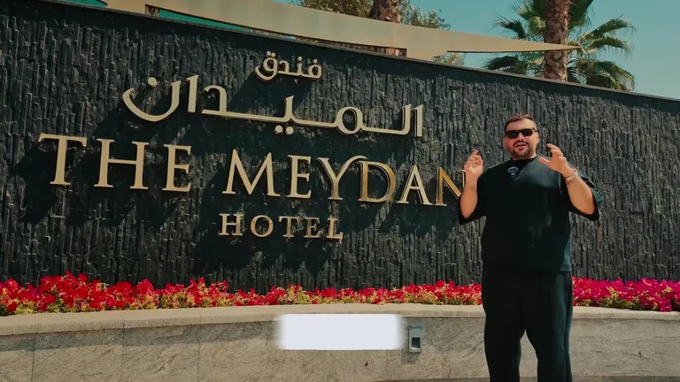 Освещенный мост в Хойане, украшенный гирляндами разноцветных фонарей, которые отражаются в воде в ночное время.