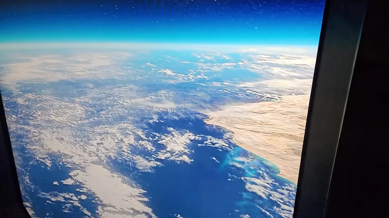 Иммерсивный экран внутри музея, демонстрирующий реалистичный вид на планету Земля из космоса.