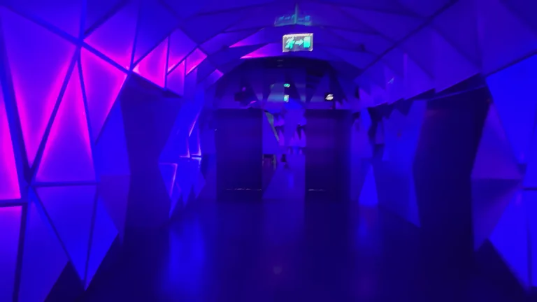 Тоннель с неоновой подсветкой и геометрическими узорами внутри здания, являющийся частью экспозиции о будущем Дубая.