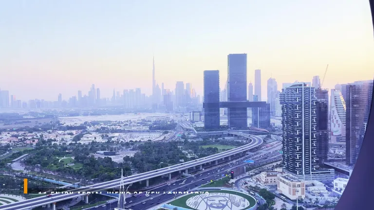 Вид на небоскреб Бурдж-Халифа и городские магистрали со смотровой площадки Рамки Дубая на закате.