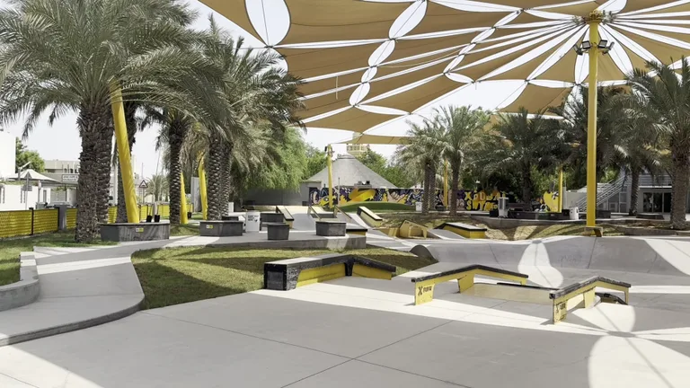 Люди занимаются кайтсерфингом на пляже Kite Beach на фоне знаменитого отеля Бурдж-Аль-Араб.