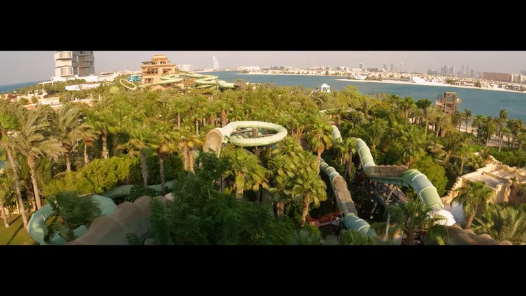 Общий вид территории аквапарка Aquaventure с центральной башней в стиле зиккурата и окружающими бассейнами.