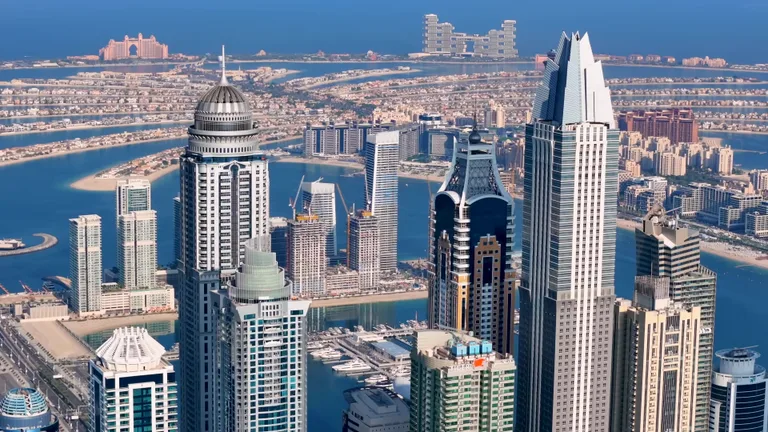 Вид сверху на плотную застройку современных высотных зданий и небоскребов в районе Дубай Марина.