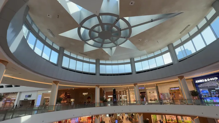 Потолочное окно в форме звезды, освещающее внутренние галереи торгового центра.