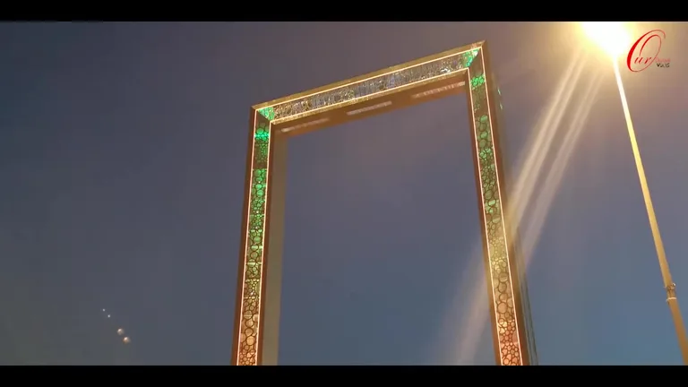 Ночная подсветка фасада Рамки Дубая с использованием светящихся узоров на фоне темного неба.