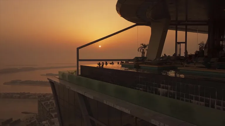 Аэроснимок башни Aura Skypool и окружающего городского пейзажа Дубая на фоне береговой линии.