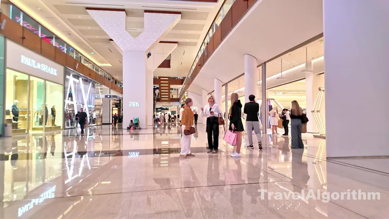 Просторные крытые аллеи Dubai Mall с магазинами люксовых брендов, равномерным ярким освещением и гуляющими посетителями.