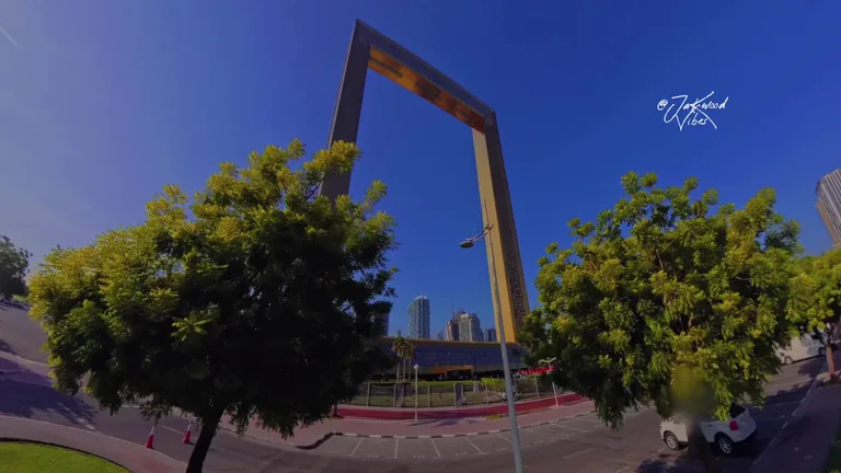 Знаменитая архитектурная рамка Dubai Frame, расположенная на территории парка Забиль в окружении зеленых деревьев.