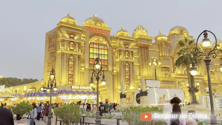 Многоэтажное здание павильона Индии с куполами и светящейся красной вывеской в сумерках.