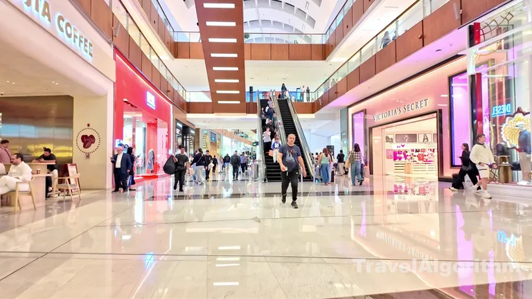 Просторный коридор торгового центра Dubai Mall с витриной магазина Victoria's Secret и проходящими мимо покупателями.