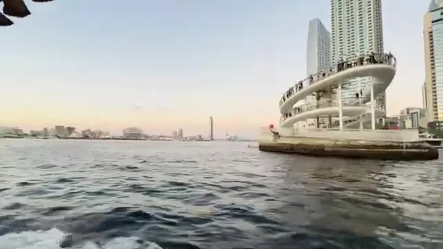 Белая многоуровневая пешеходная платформа The Viewing Point, выступающая над водой, на фоне современных высотных зданий.