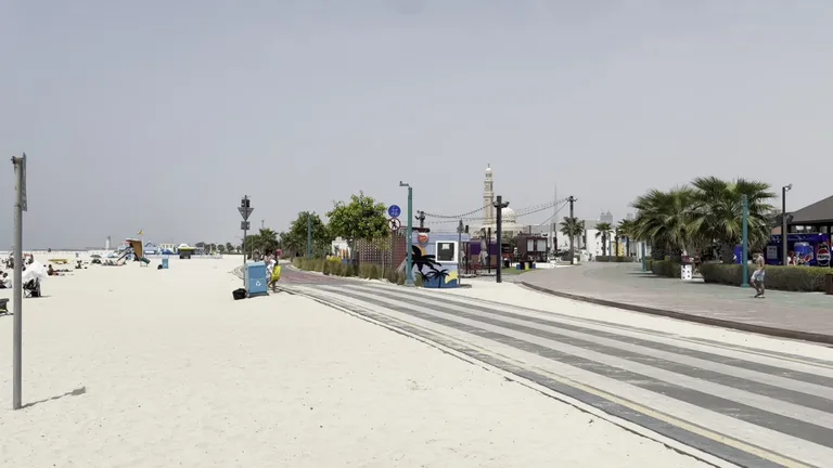 Шезлонги и зонтики, доступные для аренды отдыхающим на благоустроенном общественном пляже Kite Beach.