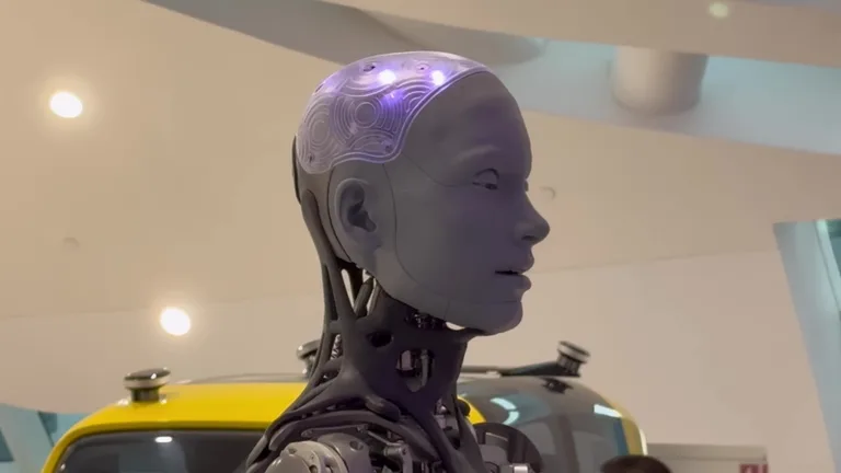 Голова человекоподобного робота с полупрозрачным черепом и видимыми внутренними микросхемами на выставке.