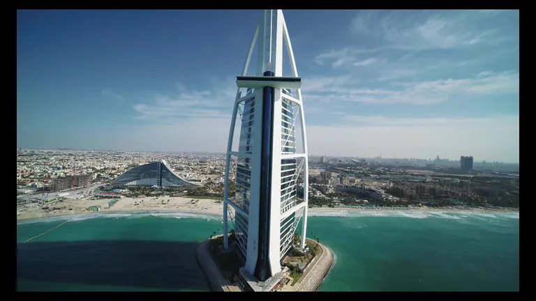 Симметричный вид сверху на Бурдж-эль-Араб, расположенный на искусственном острове, с вертолетной площадкой на верхнем ярусе.